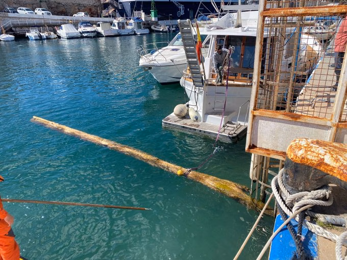 (La foto) Salvamento Marítimo retira un peligroso tronco frente al puerto de Ciutadella