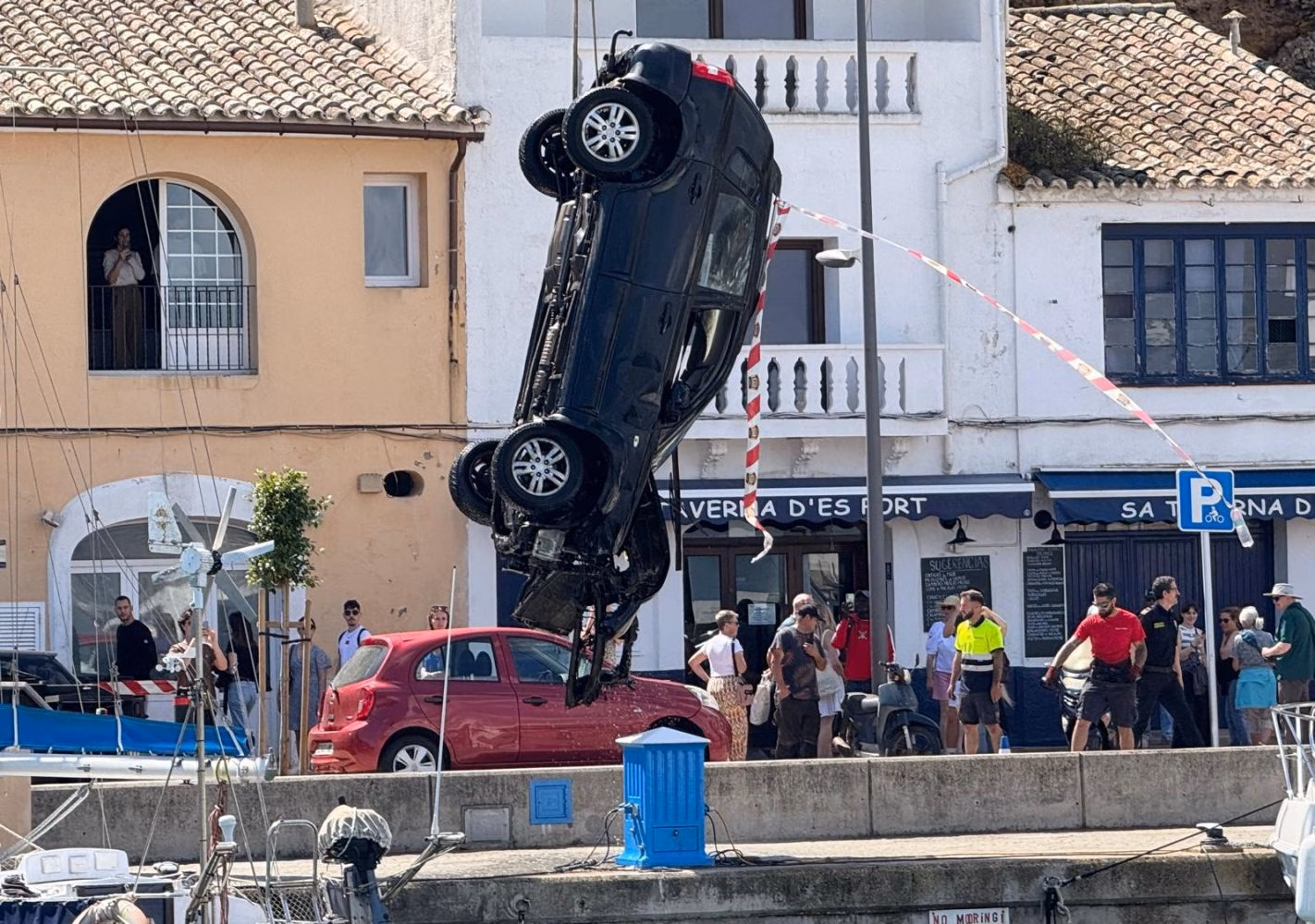 (Fotos y vídeo) Retiran con una grúa un coche que cayó al agua en el puerto de Maó